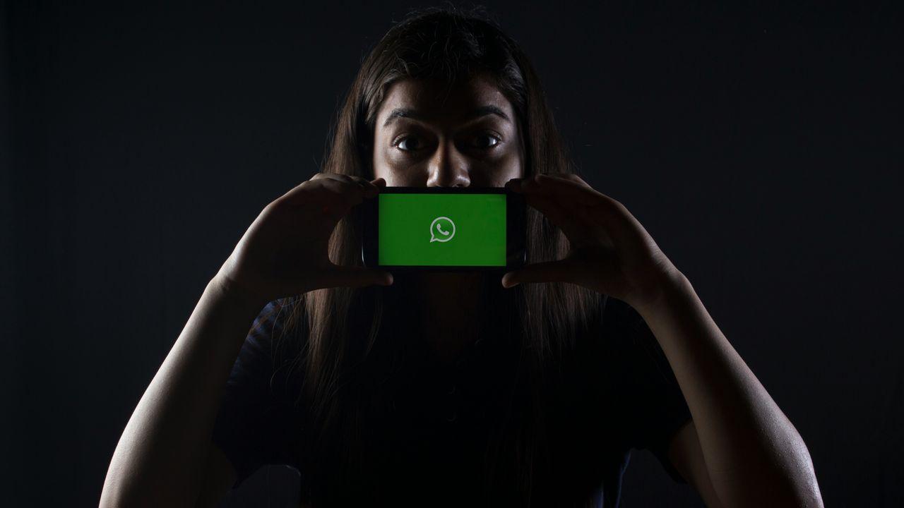 Una chica se pone el móvil en la cara con la app de WhatsApp