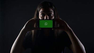 Una chica se pone el móvil en la cara con la app de WhatsApp
