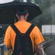 Un hombre camina con el paraguas para no mojarse
