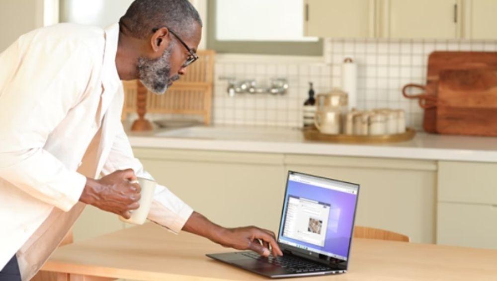 Un hombre usa su portátil con Office en la cocina