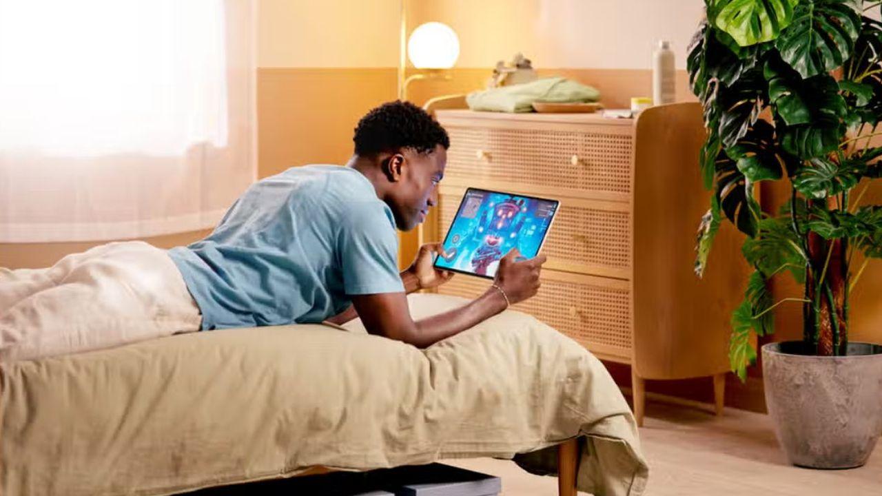 Un chico tumbado en la cama jugando con el Galaxy Tab S9 Ultra 5G