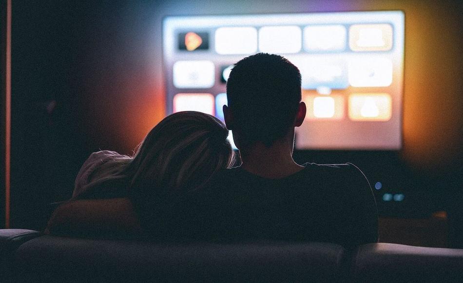 Una pareja viendo la televisión a oscuras