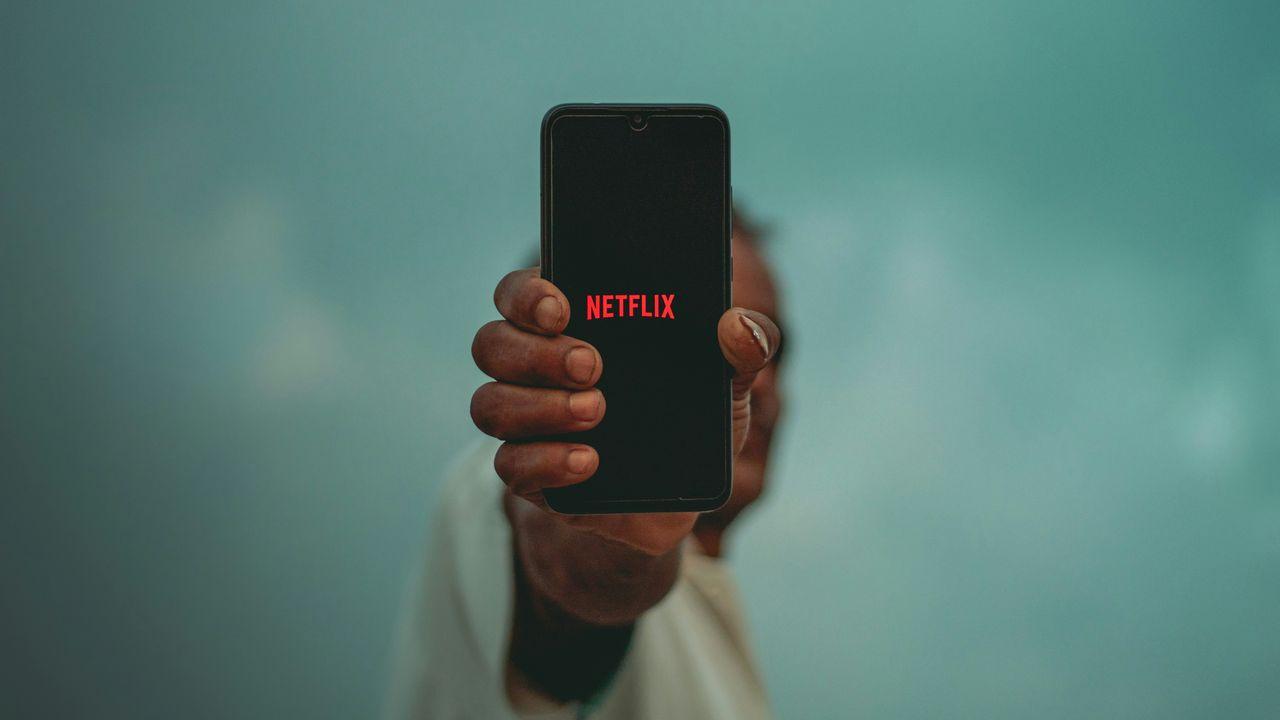 Una persona sujeta el móvil y enseña Netflix en la pantalla