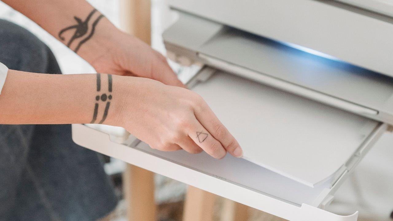 Un usuario poniendo papel en su impresora de casa