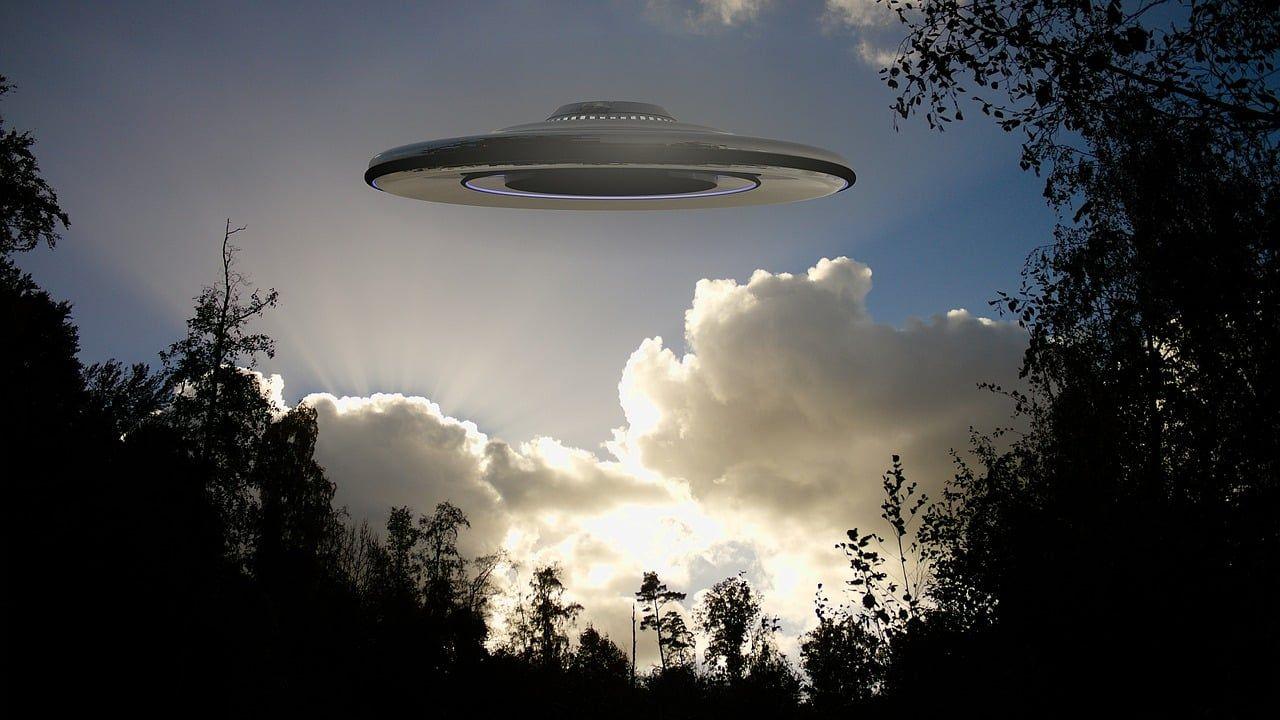 Un UFO en el cielo con pocas nubes alrededor