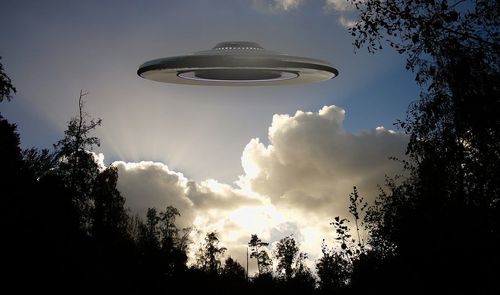Un UFO en el cielo con pocas nubes alrededor