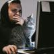 Un chico navega por Internet mientras su gato está con él
