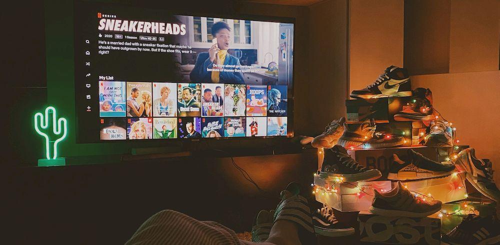 Un usuario tumbado viendo Netflix en la televisión