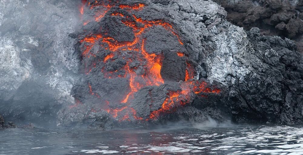 Lava procedente de un volcán llegando hasta el océano