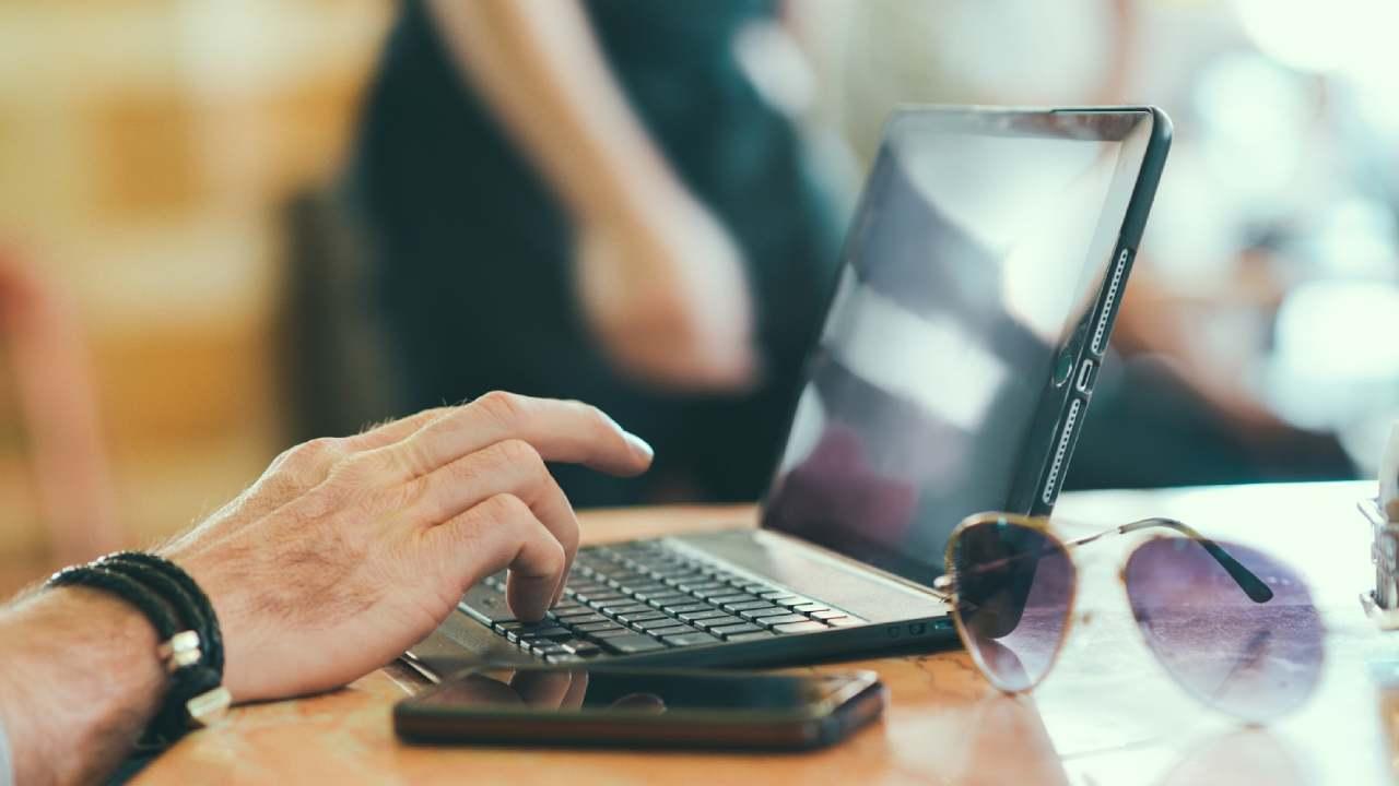 Una mano usando una tablet con teclado.