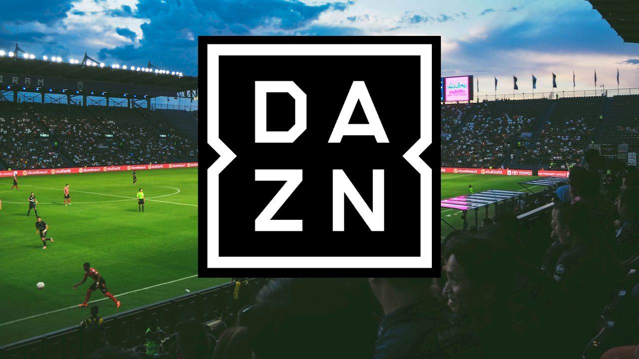 El logo de DAZN sobre un campo de fútbol con los aficionados