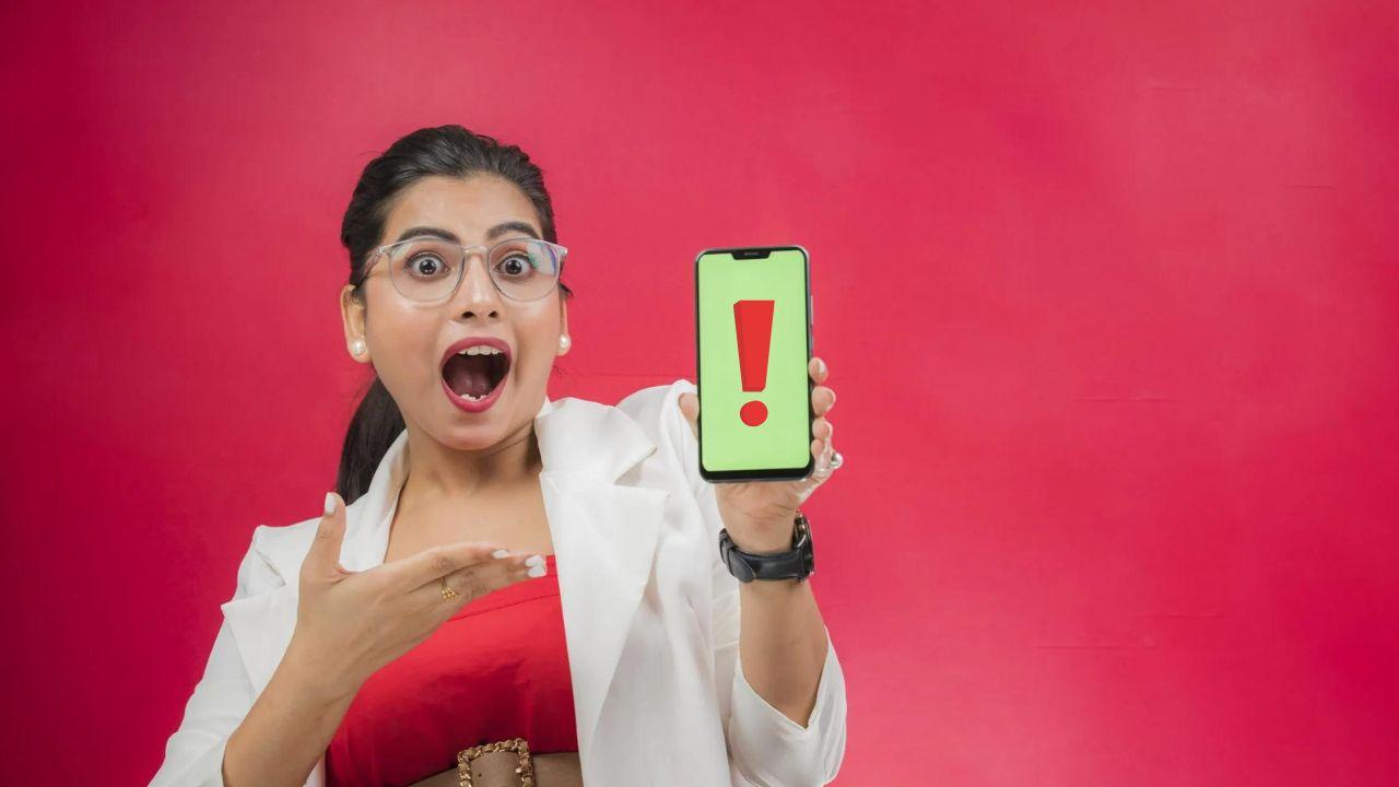 A girl holds a mobile phone with a surprised face