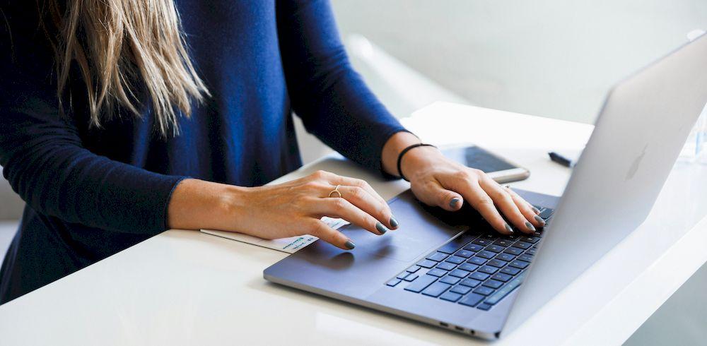 Una mujer trabaja en la oficina con su ordenador portátil