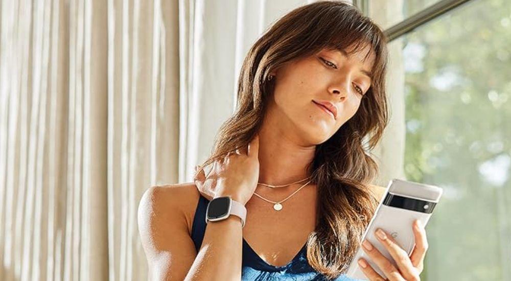 Una mujer utilizando una pulsera de actividad marca Fitbit