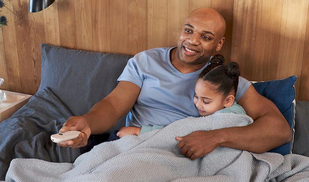 Padre e hija usando el mando de un dispositivo Chromecast