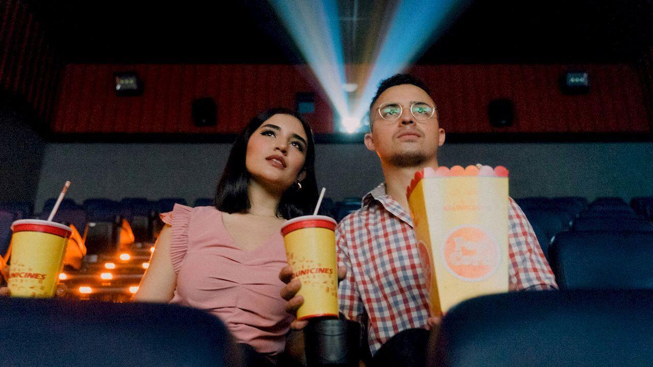 Una pareja viendo una película dentro de una sala de cine