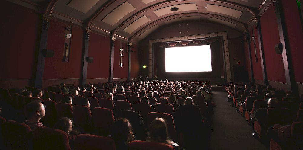 Espectadores sentados viendo una película en una sala de cine