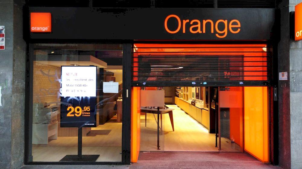 Tienda de Orange desde el exterior con la persiana medio bajada