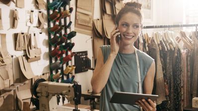 Trabajadora autónoma usando dispositivos en su lugar de trabajo.