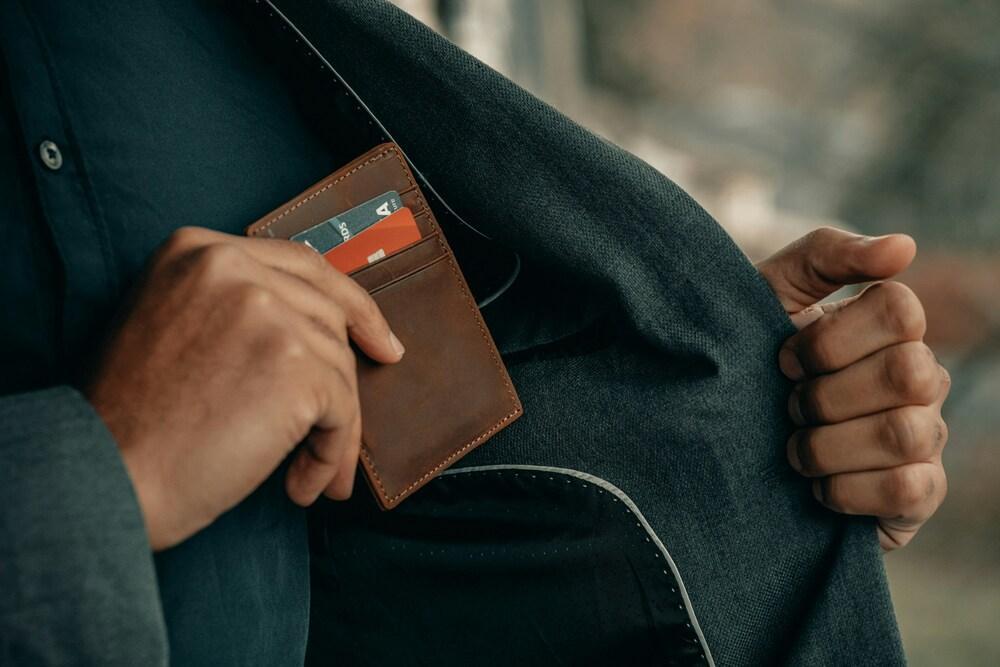 persona con una cartera con tarjetas