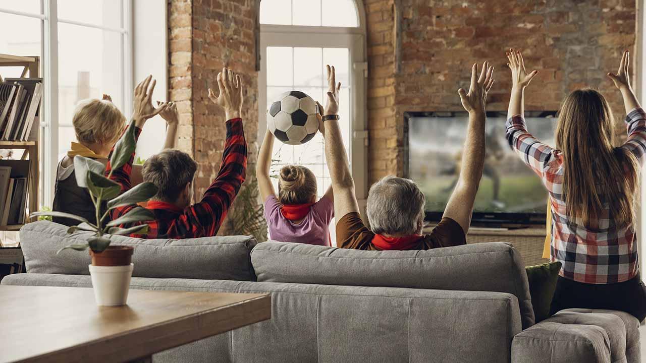 Familia viendo fútbol en casa