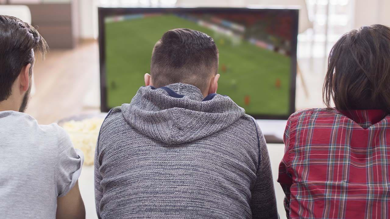 grupo de amigo viendo deporte en la TV