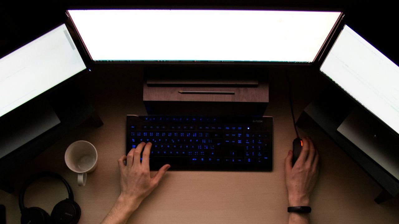 Múltiples pantallas de ordenador en blanco y un teclado.