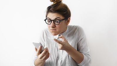 mujer enfadada mirando el móvil