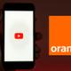 YouTube en smartphone junto al logo de Orange.