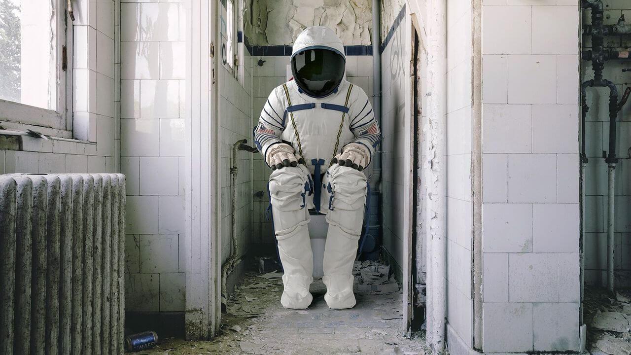 Un astronauta sentado en el retrate haciendo sus necesidades