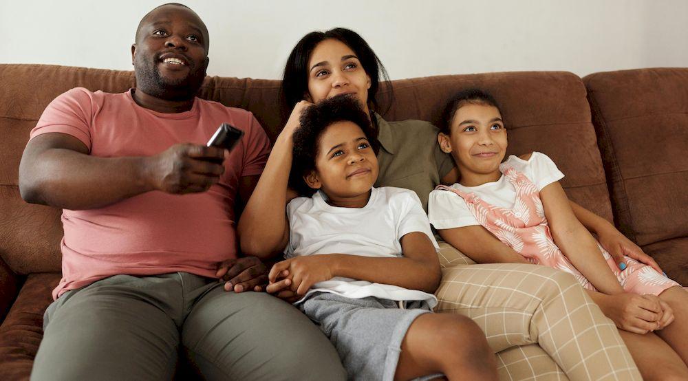 Una familia viendo la televisión contenta y feliz