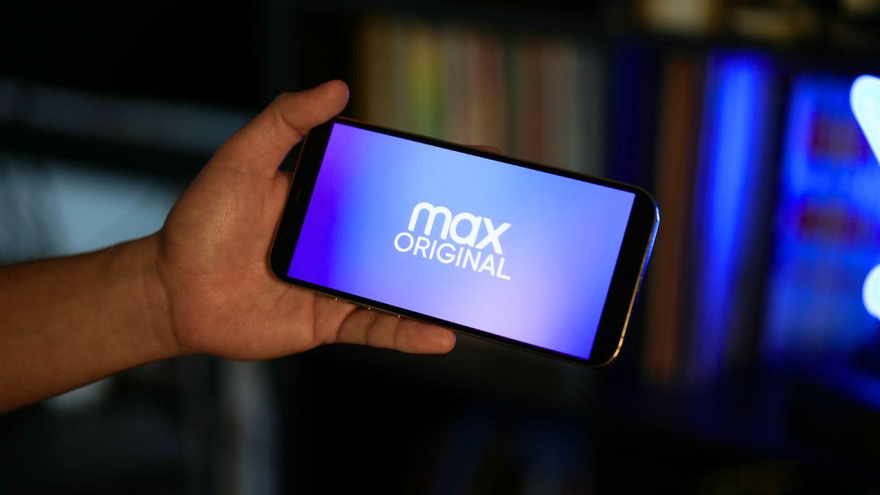 Un usuario sujeta un móvil con el logo de Max original