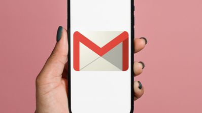 Una mano sujetando un móvil enseñando el icono del correo de Gmail