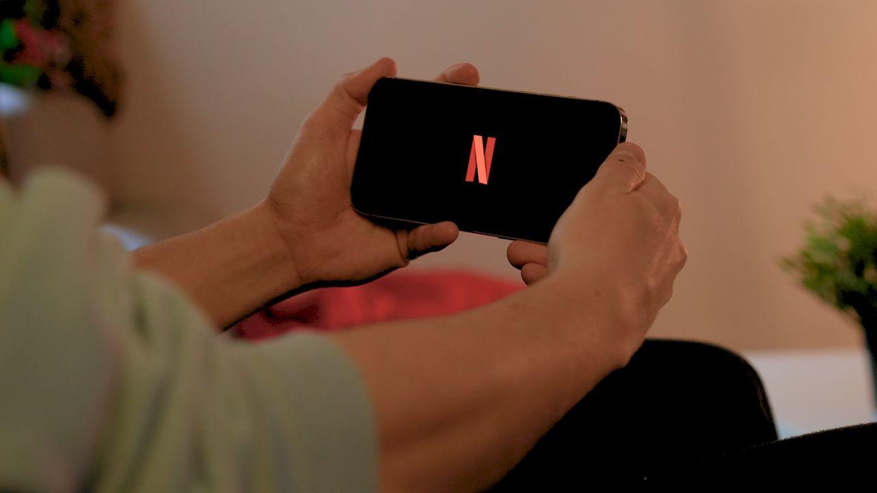 Un usuario sujeta el móvil con Netflix en posición horizontal