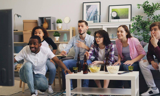 Un grupo de amigos viendo deportes en conjunto