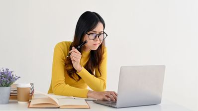 Chica con dudas utiliza su ordenador portátil mientras ve algo