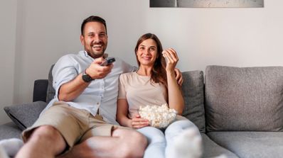 Una pareja sentada en el sofá viendo la televisión