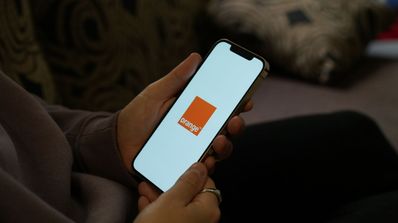 Una persona usa un móvil con el logo de Orange