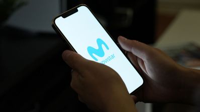 Un usuario sujeta un móvil con el logo de Movistar