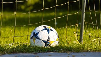 Un balón en el fondo de la red de una portería de fútbol
