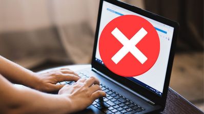 Tecleando en un ordenador portátil con un mensaje de error en pantalla