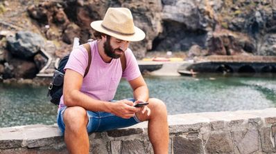 Un viajero se sienta mientras usa los datos de roaming
