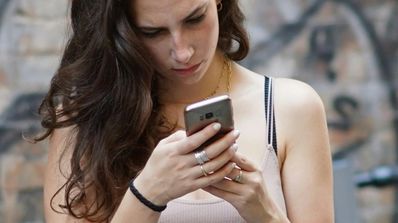 Una chica usa su teléfono móvil
