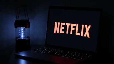 Ordenador portátil con el logo de Netflix y una linterna