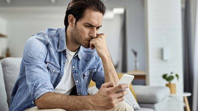 hombre preocupado mirando móvil