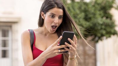mujer sorprendida mirando móvil