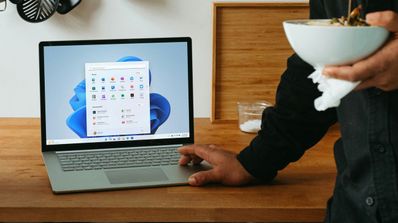 Un hombre usando el portátil con Windows 11 en la cocina