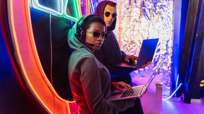 Dos hackers usando el portátil con el modo Dios