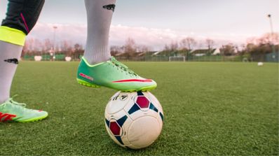 Un jugador de fútbol pisa una pelota mientras está en el campo
