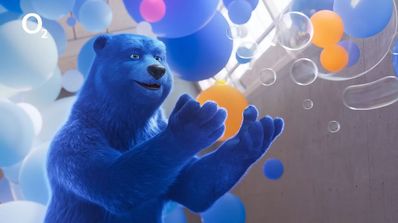 El oso mascota de O2 feliz mientras recoge algo en el aire